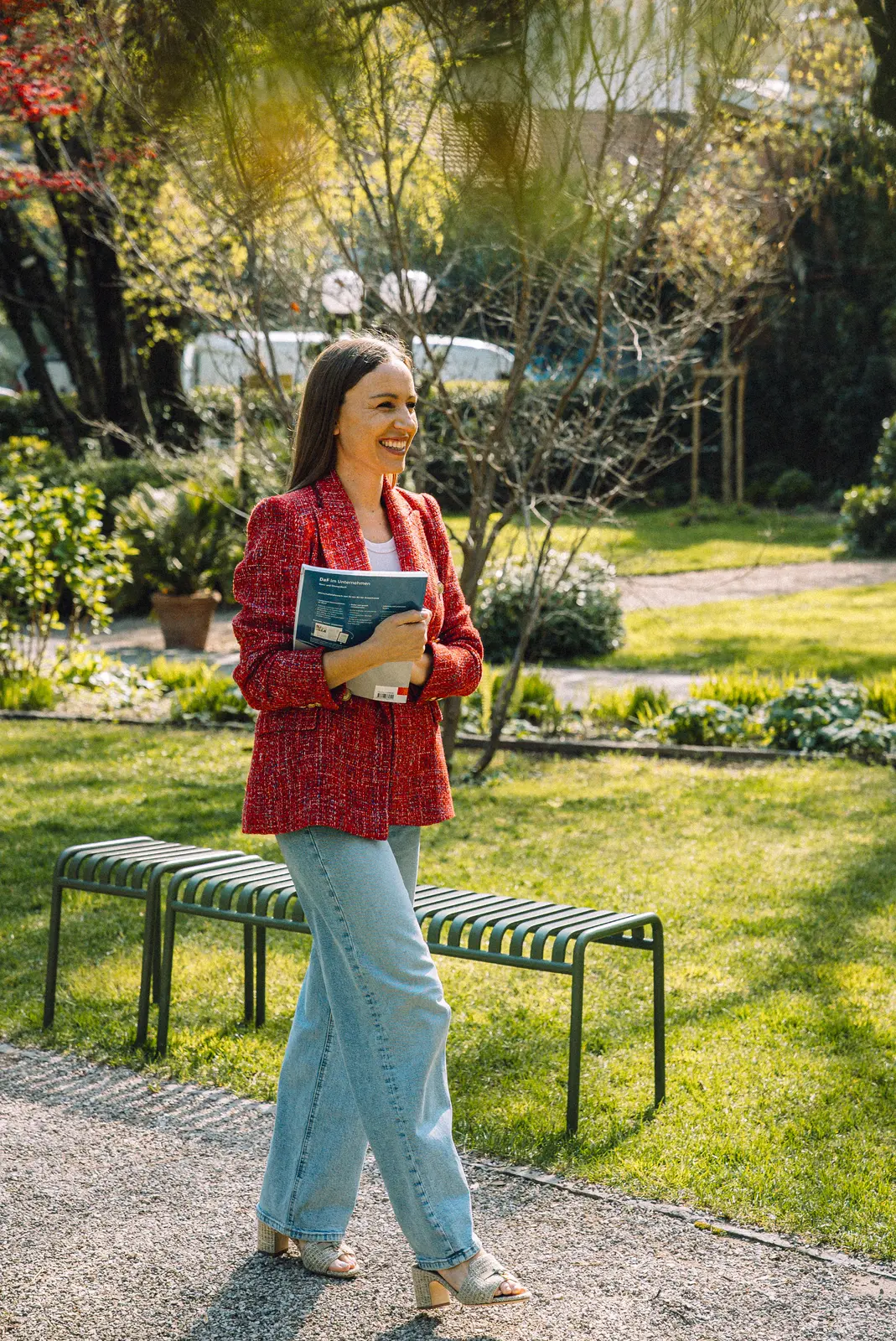 Lena walking through a garden with a notebook
