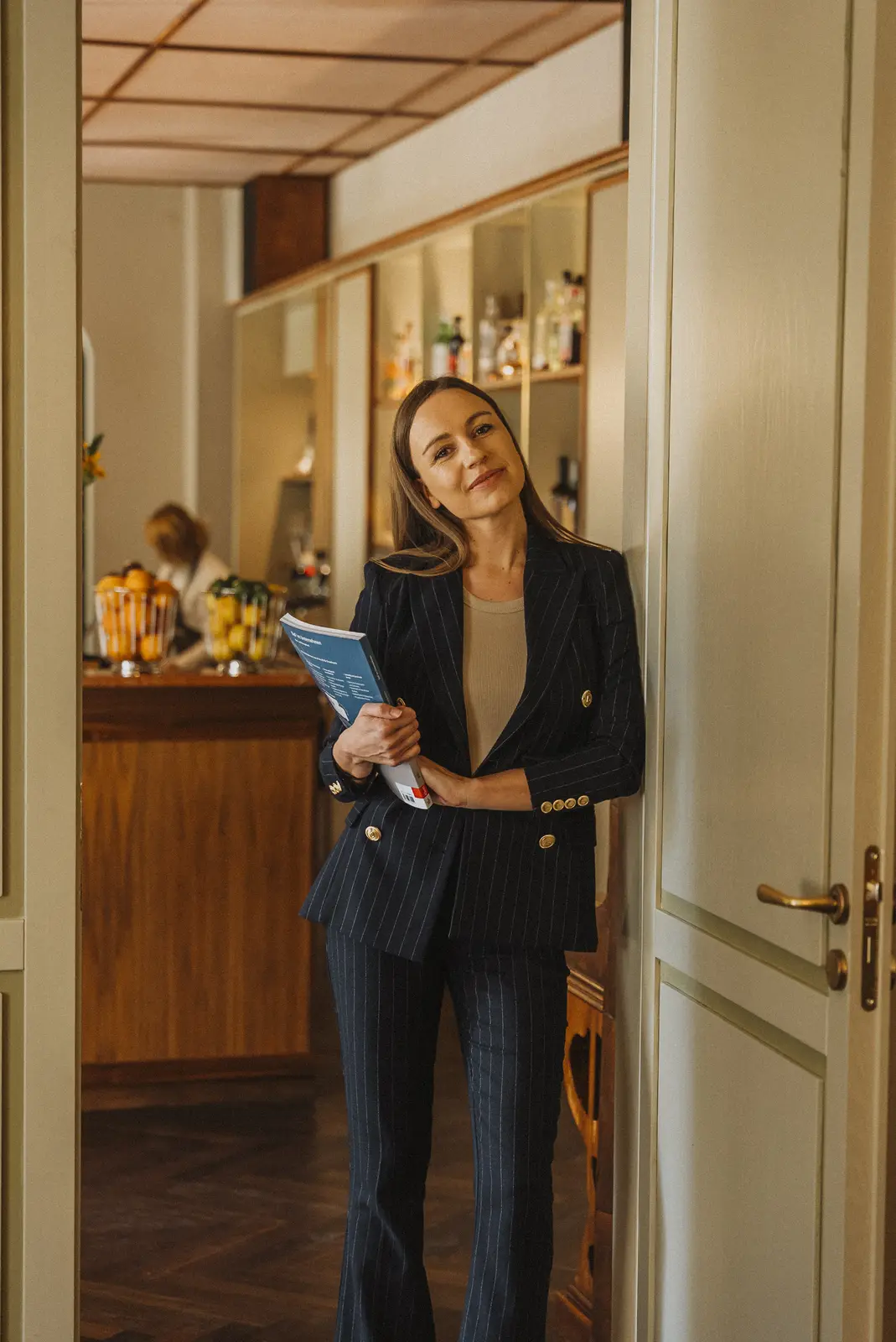 Lena lächelt in der Tür einer Hotelbar