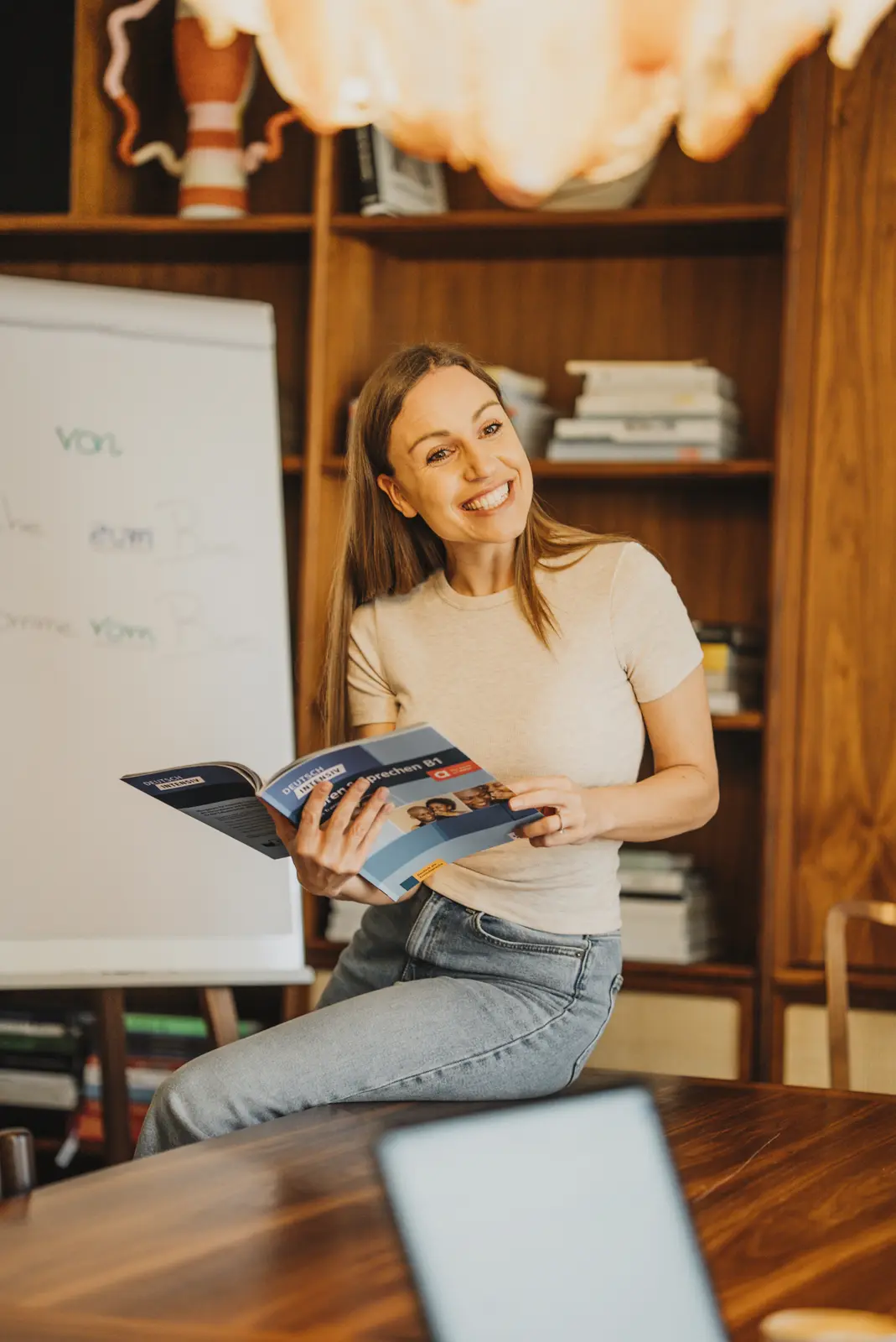 Lena reading from a course book in front of a whiteboard